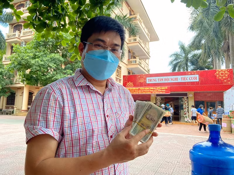 Anh Điêu Bình Dương tiếp nhận số tiền ủng hộ để chuyển vào tài khoản của Ủy ban Mặt trận Tổ quốc huyện. Ảnh: Điêu Bình Dương