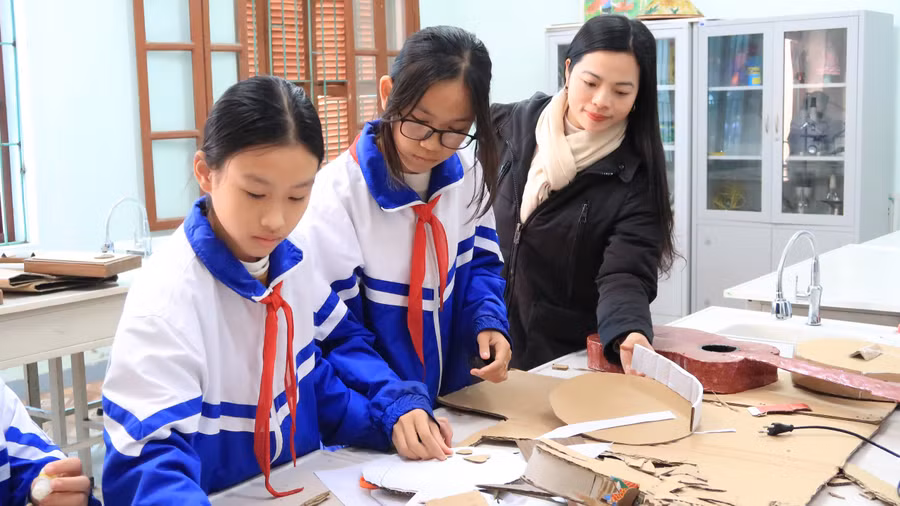 Cô giáo Nguyễn Thị Hằng đang cùng học sinh CLB Mĩ thuật Trường THCS Trường Thọ làm đàn Đáy.