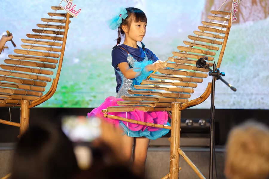 Học sinh tự tin biểu diễn một bản nhạc quốc tế sôi động bằng cây đàn T’rưng truyền thống của Việt Nam.