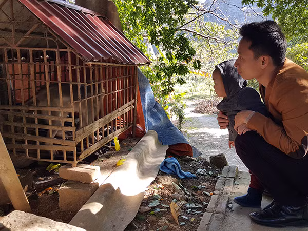 Du khách đang ngắm nhìn một "đại thánh" bị nhốt trong lồng sắt dưới chân núi Nhẫm