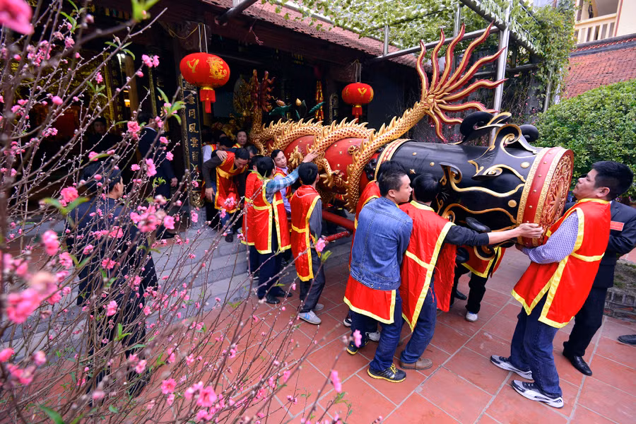 Từ 6h, các chú tùy (mặc áo đỏ, vàng) đưa quả pháo Nhất (dài 6 m) và pháo Nhì (dài 5,8 m) ra ngoài nhà truyền thống để chuẩn bị rước về đình làng.