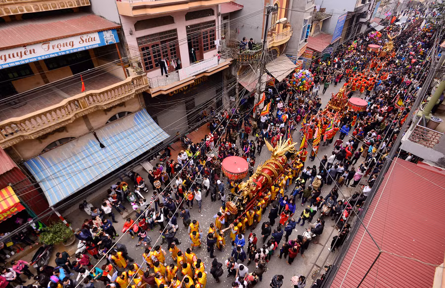 Người dân trong làng và khách thập phương đứng hai bên đường chào đón đám rước đi qua. Nếu như trước đây, hai quả pháo khổng lồ được rước từ nhà một vị quan đám ra đình làng là loại thật thì nay nó chỉ còn mang tính chất tượng trưng.