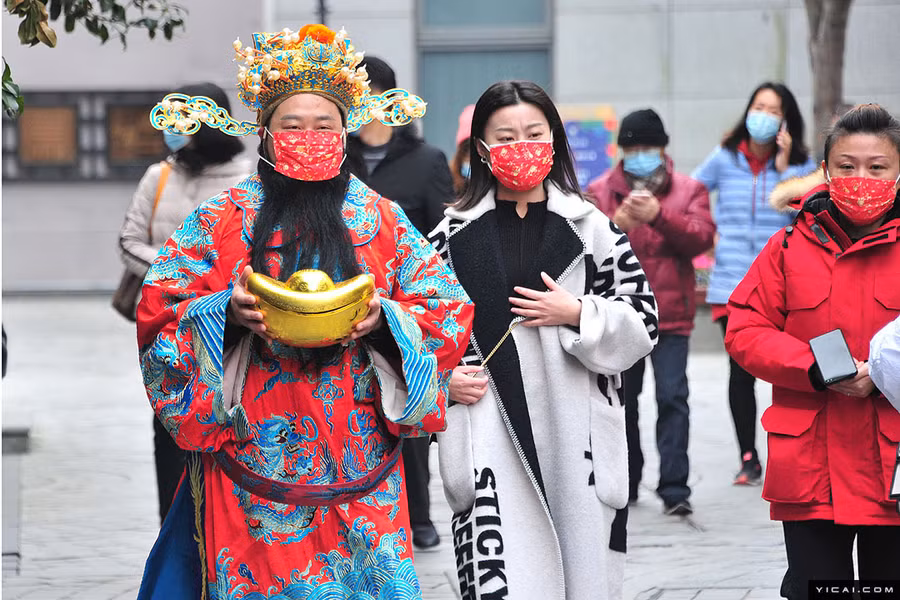 Một người đàn ông hóa trang thành Thần Tài mang "đồng tiền vàng" ở Thượng Hải.