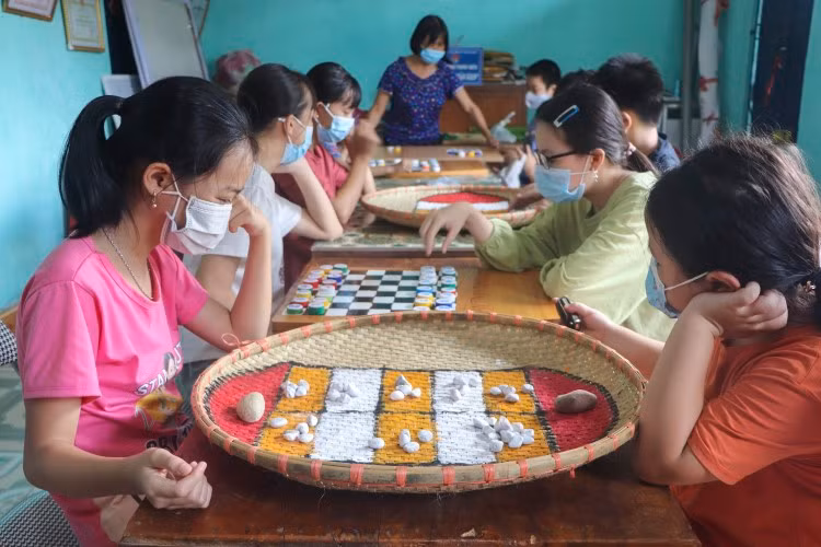 Trò chơi dân gian ô ăn quan thu hút nhiều em tham gia.