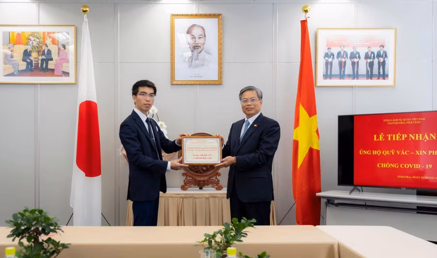 Anh Trần Nhân Đồng (bên trái) trao tặng số tiền thu được từ chương trình bán sữa cho Tổng Lãnh sự quán Việt Nam tại tỉnh Fukuoka gửi về Quỹ vắc-xin của Việt Nam. Ảnh: NVCC