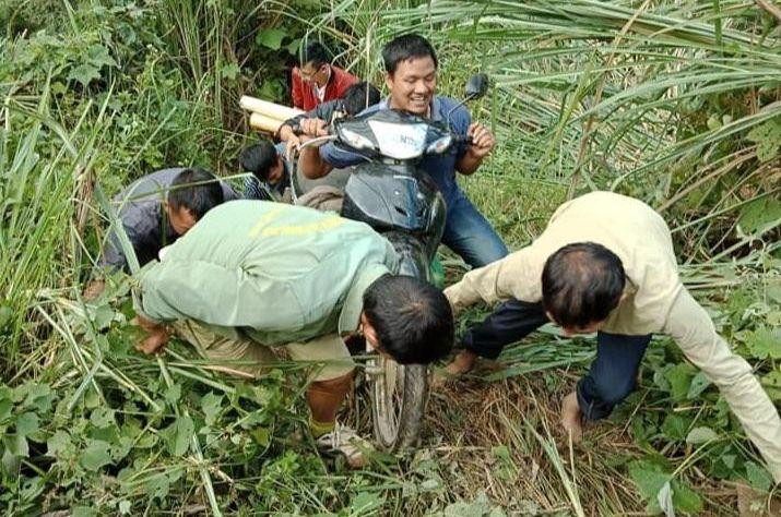 Người dân giúp đỡ thầy cô đưa xe lên khỏi vục thẳm. Ảnh: NVCC