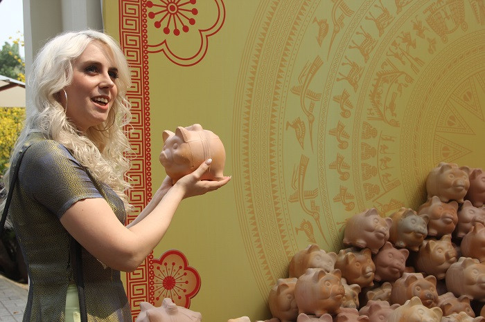 Khách nước ngoài thích thú với những chú heo đất được trang trí tại Phố ông Đồ.