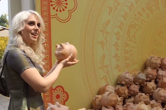 Khách nước ngoài thích thú với những chú heo đất được trang trí tại Phố ông Đồ.