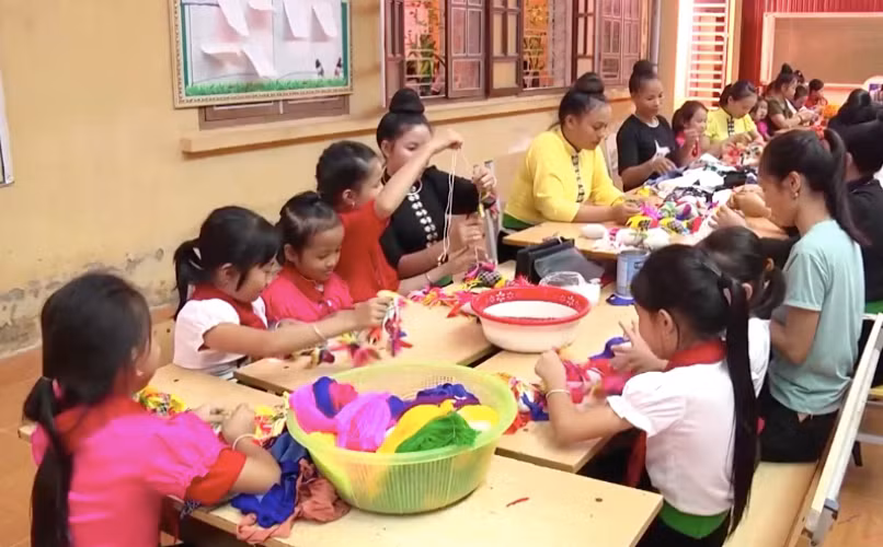 Giáo viên Trường tiểu học Hạnh Sơn, TX Nghĩa Lộ hướng dẫn học sinh trải nghiệm bản sắc văn hóa địa phương. Ảnh: TG