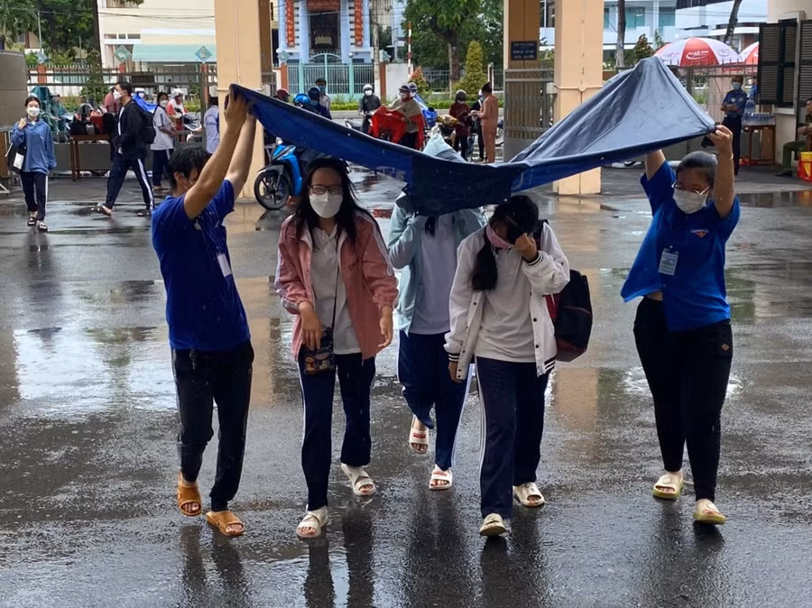 Thí sinh tỉnh Tiền Giang đội mưa đến điểm thi làm thủ tục dự thi chiều 6/7.