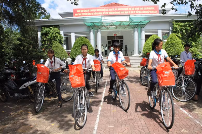 Các em HS vui mừng nhận chiếc xe đạp mới từ chương trình Tiếp sức đến trường