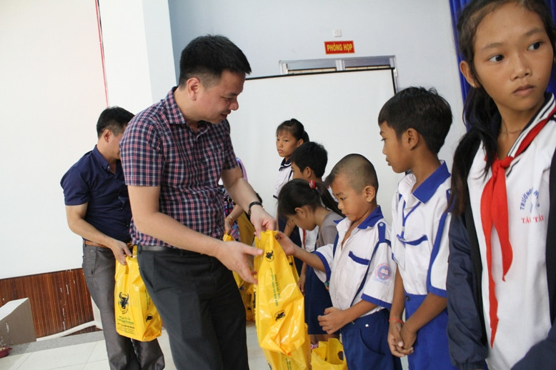 Nhà báo Triệu Ngọc Lâm - Tổng Biên tập báo Giáo dục và Thời đại trao quà cho các em HS