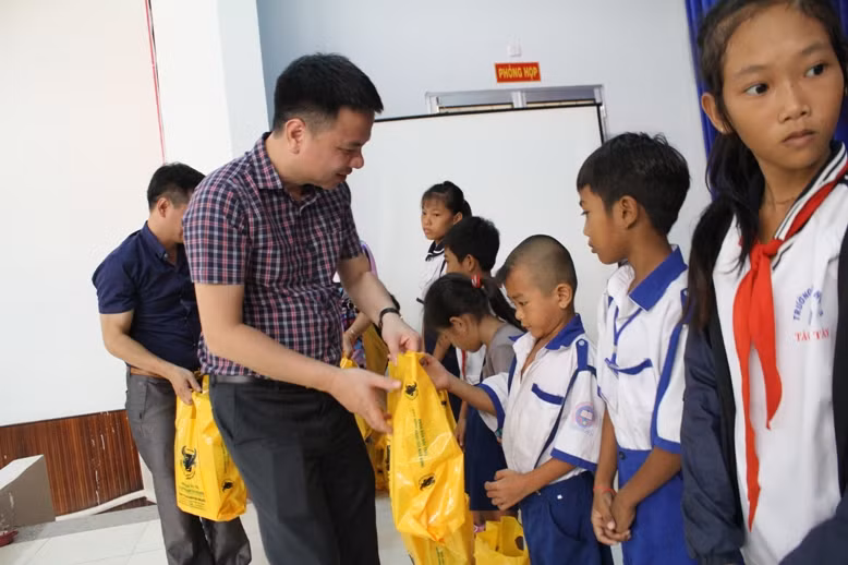 Nhà báo Triệu Ngọc Lâm - Tổng Biên tập báo Giáo dục và Thời đại trao quà cho các em HS