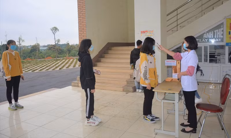 Sinh viên Trường ĐH Hùng Vương xếp hàng với khoảng cách an toàn để đo thân nhiệt trước khi lên giảng đường. Ảnh: NTCC