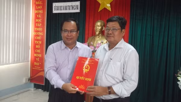 Giám đốc Sở GD&ĐT Cà Mau Nguyễn Minh Luân trao Quyết định nghỉ hưu cho Phó Giám đốc Sở GD&ĐT Cao Minh Hồng (phải)