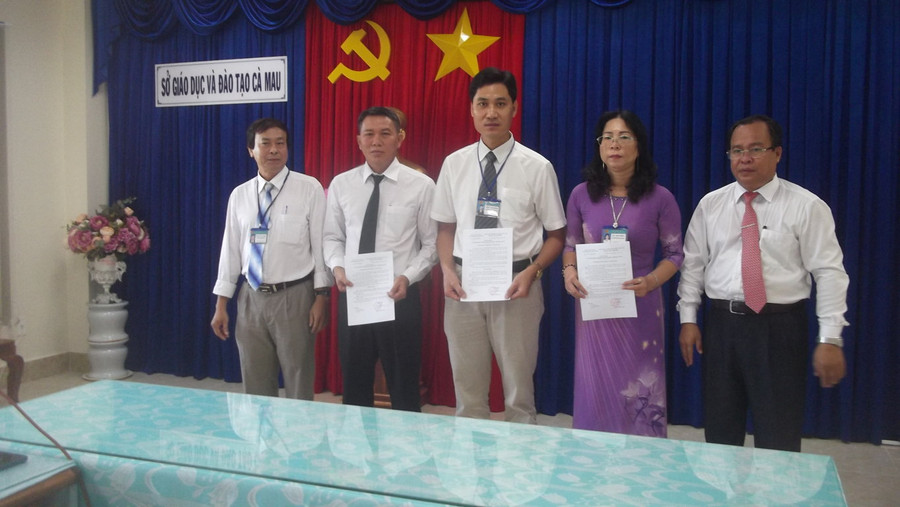 Giám đốc Sở GD&ĐT Cà Mau Nguyễn Minh Luân (phải) trao Quyết định bổ nhiệm Hiệu trưởng Trường THCS - THPT Tân Lộc cho ông Trần Văn Dũng (giữa)