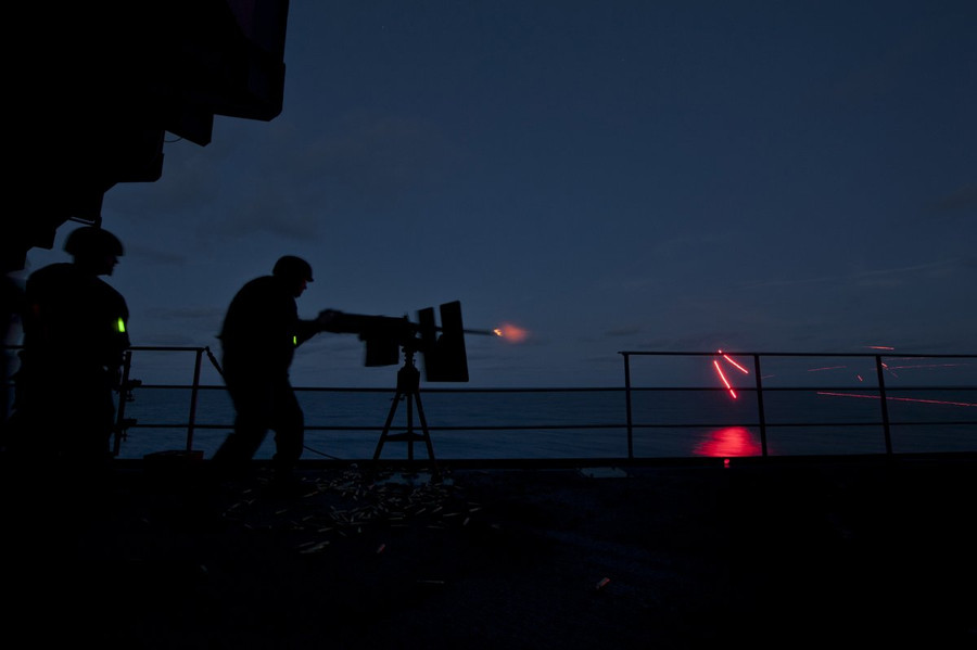 Đầu đạn rời khỏi nòng súng tạo nên những đường sáng xé toạc màn đêm khi thủy thủ khai hỏa súng máy hạng nặng 12,7 mm từ tàu sân bay USS Carl Vinson.