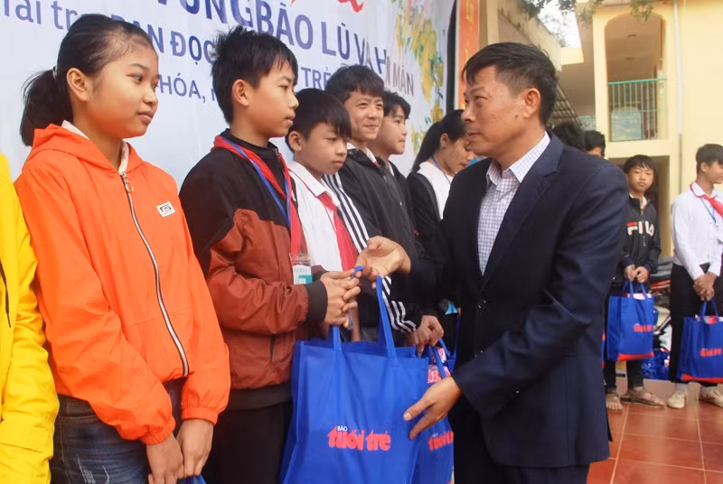 Thầy Nguyễn Văn Giang tặng quà của bạn đọc Báo Tuổi trẻ cho học sinh.