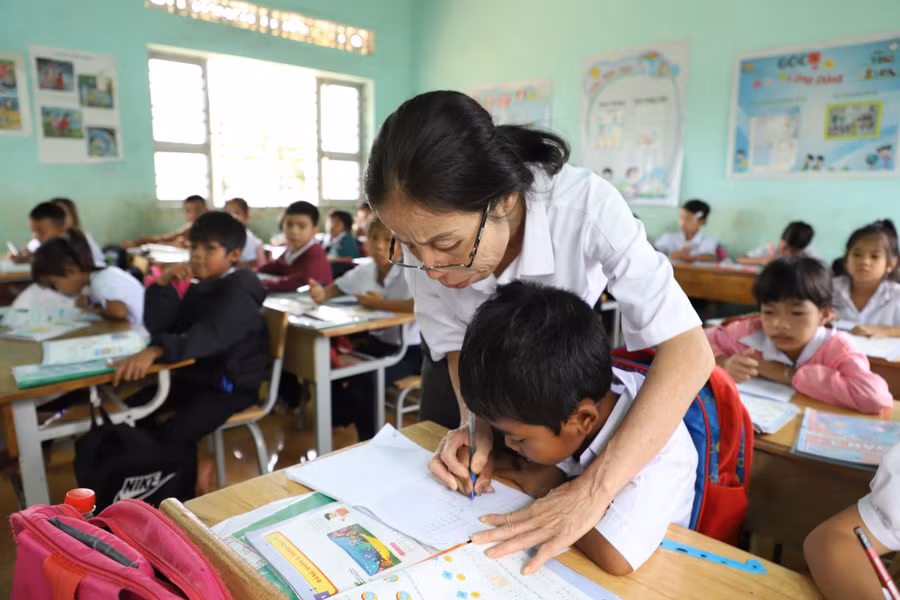 Giáo viên Trường Tiểu học Y Jút nắn nót cho học sinh từng nét chữ. Ảnh: Thành Tâm