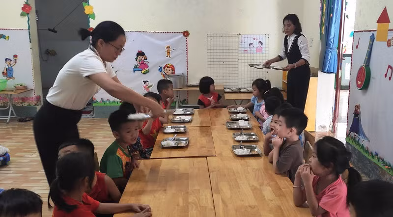 Cô giáo Trường Mầm non Tam Chung chăm sóc bữa ăn trưa cho trẻ.
