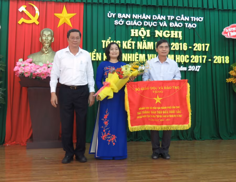 Bà Trần Hồng Thắm - Giám đốc Sở GD&ĐT TP Cần Thơ nhận Cờ thi đua của Bộ GD&ĐT