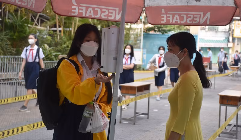 Học sinh Trường THCS Chánh Hưng (Quận 8, TPHCM) kiểm tra y tế trước khi vào trường.