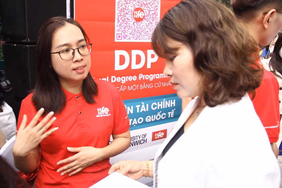 Phụ huynh tìm hiểu về chương trình đào tạo liên kết mỗi bên cấp một bằng của Viện Đào tạo Quốc tế (Học viện Tài chính). Ảnh: Sỹ Điền