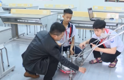 Thầy Hoàng Văn Thắng hướng dẫn hai em học sinh thực hiện đề tài