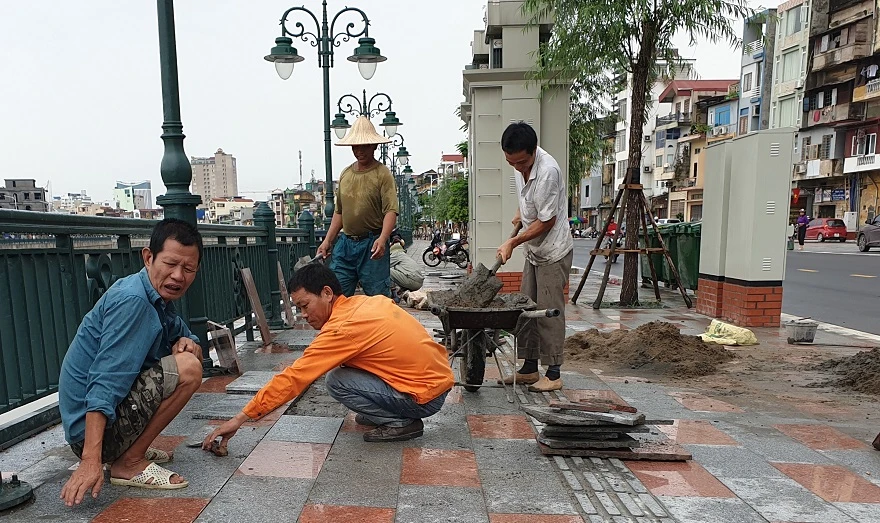 Công nhân Cty Trung Thủy đang khắc phục sự cố nứt, lún kéo dài