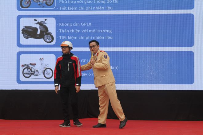 Cán bộ Đội Tuyên truyền và xử lý hướng dẫn học sinh cách đội mũ bảo hiểm