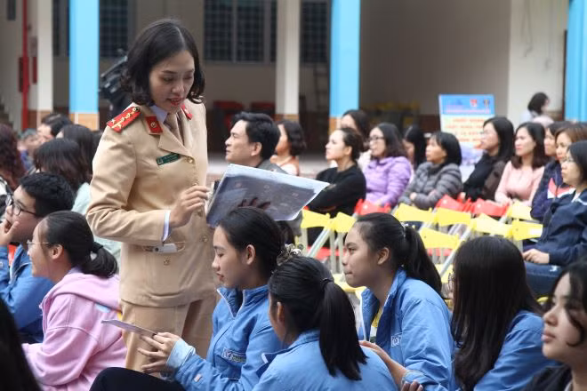 Cán bộ chiến sỹ Phòng Cảnh sát giao thông đường bộ, đường sắt phát tờ rơi về an toàn giao thông tới học sinh