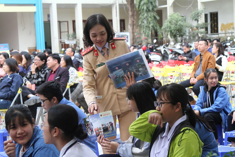 Tờ rơi về an toàn giao thông được chiến sỹ công an phát đến tay các em học sinh