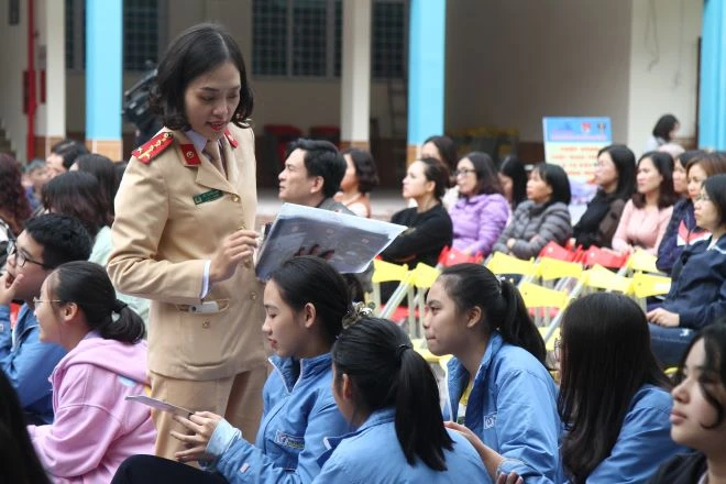 Cán bộ chiến sỹ Phòng Cảnh sát giao thông đường bộ, đường sắt phát tờ rơi về an toàn giao thông tới học sinh