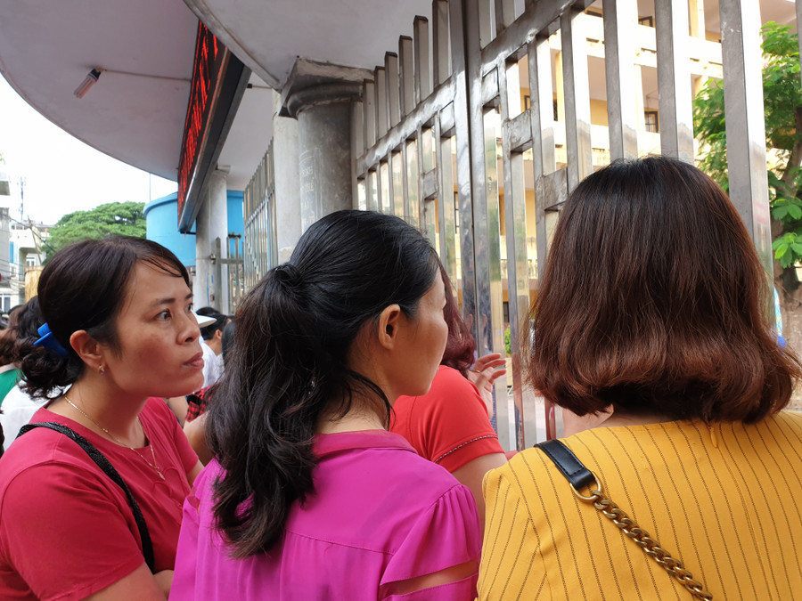 Nhiều phụ huynh đứng ngoài cổng trường ngóng đợi con