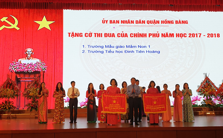 Ông Lê Khắc Nam- Phó Chủ tịch UBND huyện Vĩnh Bảo trao cờ thi đua của Chính phủ (năm học 2017-2018) cho hai đơn vị trường học của quận Hồng Bàng