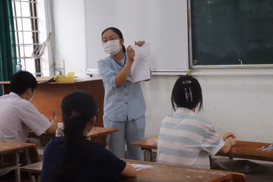 Cán bộ coi thi hướng dẫn thí sinh cách tô mã đề, số báo danh trong giấy làm bài thi.