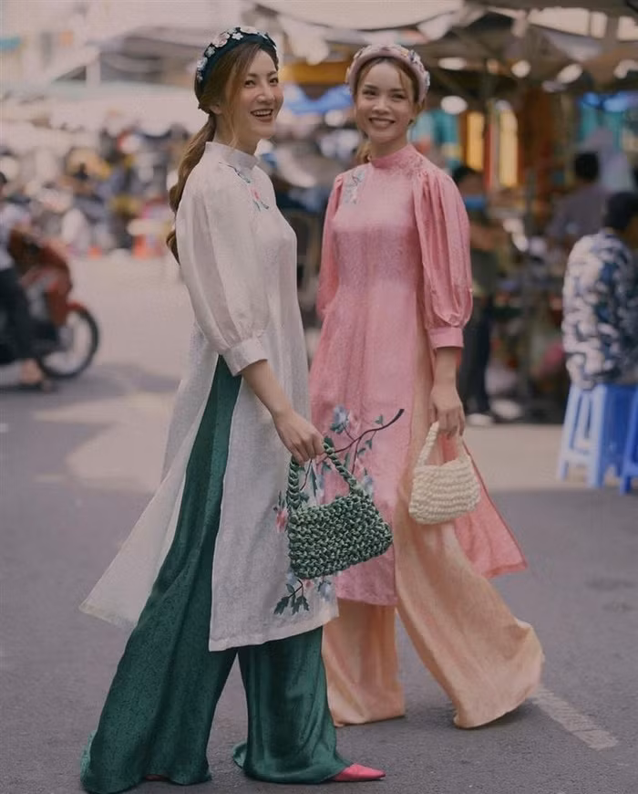 Chị em nhà Yến Trang - Yến Nhi luôn thể hiện được đẳng cấp thời trang xuất sắc vì nhanh chóng đón đầu xu hướng. Hai cô nàng ứng dụng một cách tuyệt vời chiếc làn đi chợ cách điệu cùng áo dài thêu, đậm chất vintage.