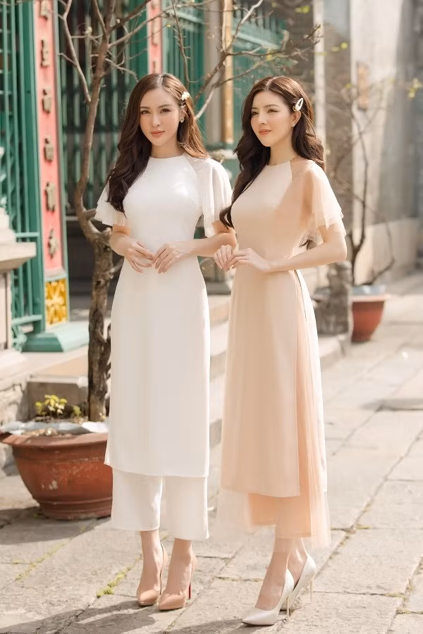 Chất liệu vải mềm mại sẽ mang đến sự nữ tính, thưới tha hơn cho người mặc. Trong hình, thay vì đội mấn quen thuộc, 2 người đẹp chọn cài đầu bằng phụ kiện là chiếc cặp tóc ngọc trai.