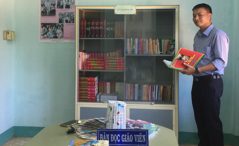 Thầy Dương Văn Vấn với mô hình “Tủ sách Bác Hồ” tại Trường THCS ĐăkRve, huyện Kon Rẫy năm 2013
