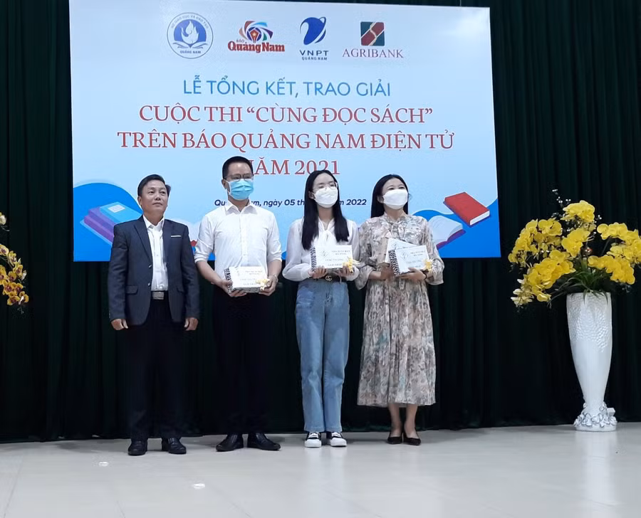 Đại diện Nhà xuất bản Đà Nẵng trao tặng phẩm cho tác giả đoạt giải Nhất và học sinh Hồ Cao Mỹ Diệp, tác giả có bài giới thiệu sách của Nhà xuất bản Đà Nẵng đoạt giải.