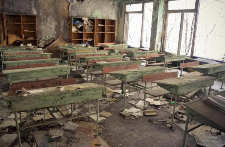 Bàn ghế, giá sách, cửa sổ của một lớp học đầy bụi. Ảnh: Caters News