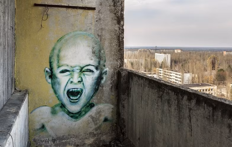 Tranh graffiti về bé trai nhiễm phóng xạ dường như đang phải chịu đau đớn được vẽ trên tường của một căn nhà hoang. Ảnh: Caters News