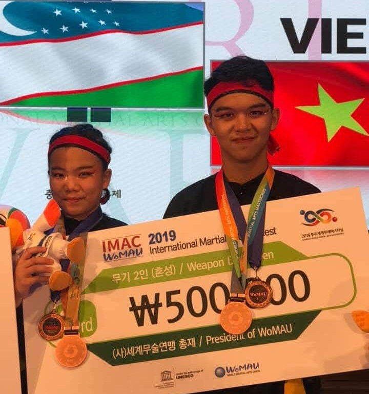 Hai học sinh Nguyễn Thị Mỹ Anh và Đặng Viết Trí giành huy chương Đồng nội dung đôi binh khí tại đại hội Võ thuật thế giới 2019 (Hàn Quốc).