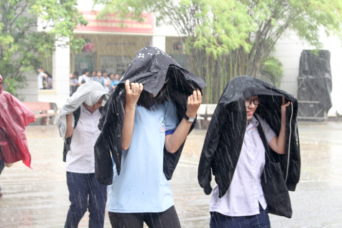 Không mang dù theo nên các em dùng áo khoác để che mưa Không mang dù theo nên các em dùng áo khoác để che mưa
