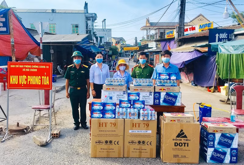 Chị Yến trao tặng khẩu trang y tế cùng các nhu yếu phẩm cho lực lượng chống dịch ở một khu phong tỏa.