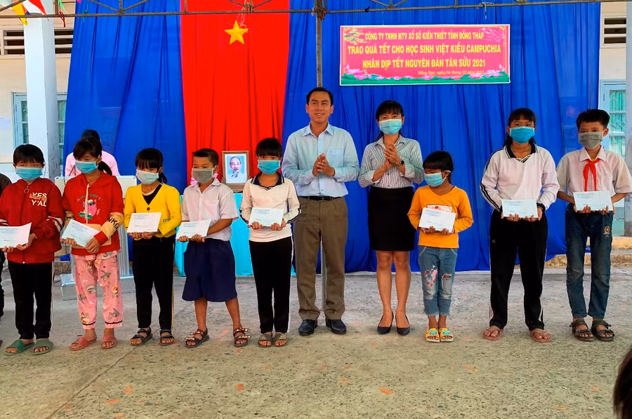 Lãnh đạo huyện Hồng Ngự và Công ty TNHH MTV xổ số kiến thiết tỉnh Đồng Tháp trao quà cho HS Việt kiều.