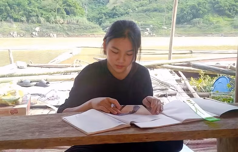 Em Ngân Thị Khanh, học sinh lớp 12C, Trường THPT Mường Lát học trực tuyến trên bè cá lồng ở sông Mã.