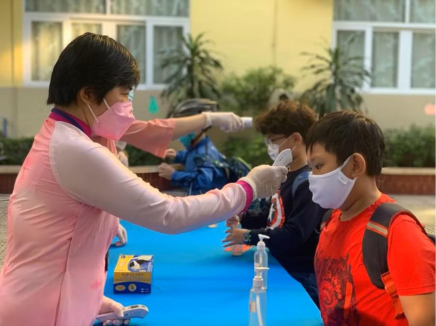 Học sinh TP.HCM được kiểm tra thân nhiệt trước khi vào trường trong. Ảnh minh hoạ 