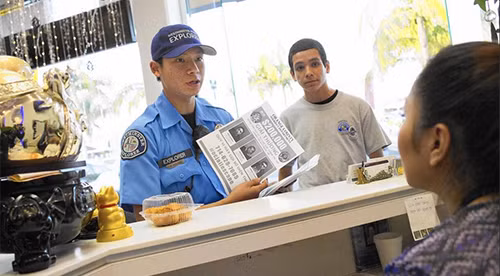 [Caption]Police Explorers Kevin Nguyen, left, and Christopher Cervantes, right, hand out fliers of the three inmates who escaped from an Orange County jail to businesses near Asian Garden Mall in Westminster in late January. (Kevin Chang / Weekend)