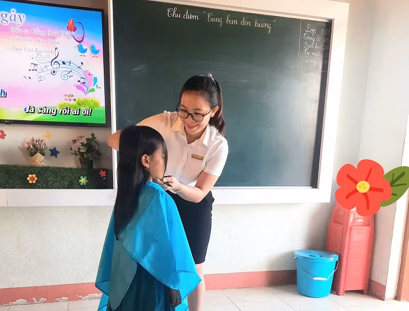 Cô Nguyễn Thị Thu Ba cắt tóc cho học sinh khi đến trường sau thời gian giãn cách.